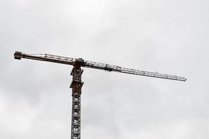 grande grue industrielle de fret de construction puissante sur un chantier de construction de nouveaux bâtiments et maisons contre le ciel photo