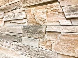 belle texture d'un mur de pierre décoratif à un angle de construction Pierre en relief texturée grise avec plâtre avec coutures. l'arrière-plan photo