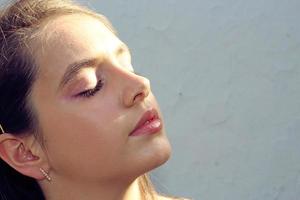 portrait d'une fille en gros plan au soleil, surligneur de peau brillant photo