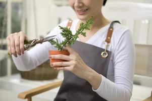 une jeune femme asiatique aime jardiner à la maison, les soins de santé et le concept de bien-être photo