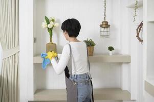 une femme asiatique avec des gants de nettoyage à l'aide d'un désinfectant à l'alcool pour nettoyer la maison, concept de mode de vie sain photo