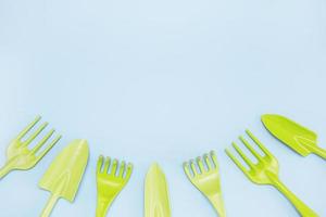 outils pour le jardinage et la floriculture râteau pelles sur fond bleu disposées d'en bas dans un demi-cercle avec espace de copie photo