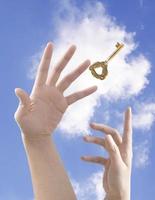 la clé du succès, main tenant la clé contre le ciel bleu photo