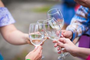 les gens trinquent avec du vin sur la terrasse d'été du café ou du restaurant photo