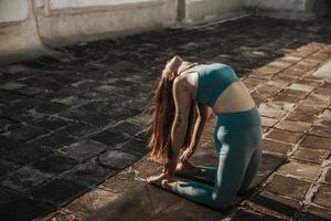 femme faisant du yoga à l'extérieur sur un toit-terrasse au coucher du soleil photo