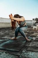 femme faisant du yoga à l'extérieur sur un toit-terrasse photo