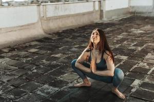 femme faisant du yoga à l'extérieur sur un toit-terrasse photo