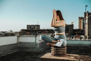 femme faisant du yoga à l'extérieur sur un toit-terrasse photo