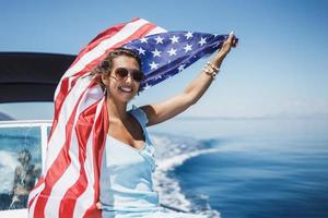 femme avec nous drapeau national passant la journée sur un yacht privé