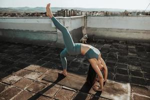 femme faisant du yoga à l'extérieur sur un toit-terrasse photo