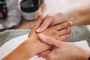 femme appréciant le massage des mains au salon de beauté photo