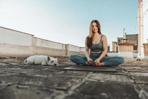 femme faisant du yoga à l'extérieur sur un toit-terrasse photo