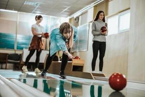 Jeune femme jouant au bowling neuf broches photo
