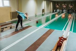 Jeune femme jouant au bowling neuf broches photo