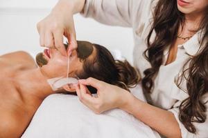 femme recevant un masque facial au salon de beauté photo