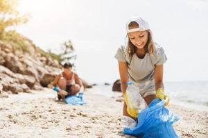 adolescent bénévole ramassant des ordures sur la plage photo