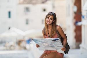 femme avec une carte explorant une ville étrangère tout en profitant des vacances d'été photo