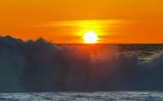 coucher de soleil doré coloré grande vague et plage puerto escondido mexique. photo