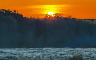 coucher de soleil doré coloré grande vague et plage puerto escondido mexique. photo