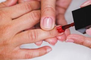 femme peignant des ongles et profitant d'un traitement de manucure dans un salon de beauté photo