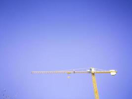 grue de construction jaune isolée sur fond de ciel bleu photo