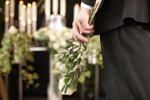 Chagrin - homme aux roses blanches à l'enterrement de l'urne photo