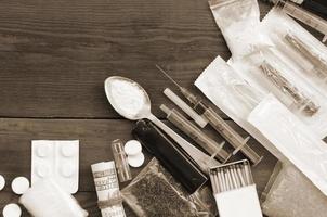beaucoup de substances narcotiques et de dispositifs pour la préparation de drogues se trouvent sur une vieille table en bois photo