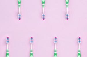 beaucoup de brosses à dents se trouvent sur un fond rose pastel photo
