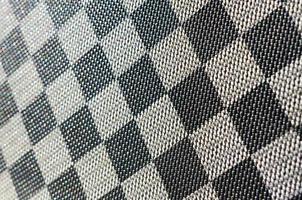 texture plastique en forme de toute petite reliure en toile, peinte en noir et gris à la manière d'un échiquier. prise de vue macro photo