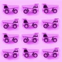 De nombreux petits camions jouets violets sur fond de texture de papier de couleur violet pastel mode photo