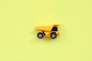 petit camion jouet jaune sur fond de texture de papier de couleur jaune pastel de mode dans un concept minimal photo