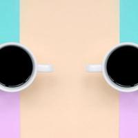 deux petites tasses à café blanches sur fond de texture de papier de mode pastel rose, bleu, corail et citron vert photo