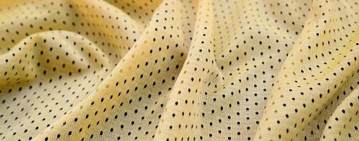 texture et fond de tissu de vêtements de maillot de sport jaune avec de nombreux plis photo