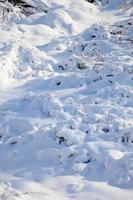 fragment de route recouvert d'une épaisse couche de neige. la texture de la couverture de neige scintillante photo