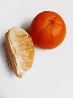 tranches de mandarine et mandarine entière sur fond blanc photo