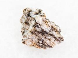 pierre de gneiss brut sur marbre blanc photo