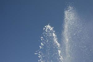 jets d'eau contre le ciel. fontaine en ville. détails de la fontaine dans la rue. photo