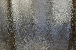 vagues sur l'eau. vent à la surface de l'eau. reflet dans la flaque d'eau. photo