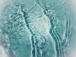 défocalisation floue transparente bleu clair texture de surface de l'eau calme avec des éclaboussures et des bulles. fond de nature abstraite à la mode. vagues d'eau au soleil avec espace de copie. aquarelle bleue brillante photo