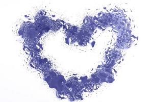 coeur violet sous la surface du verre avec des gouttes d'eau à proximité. fond de valentines, amour, concept de date photo