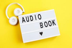 livre audio d'inscription sur une boîte à lumière avec un casque blanc moderne sur fond jaune photo