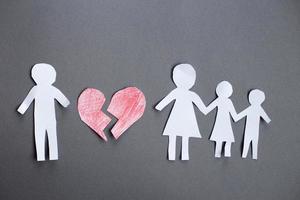 chaîne de papier coupe famille avec cœur brisé sur fond gris. divorce et concept de famille brisée photo