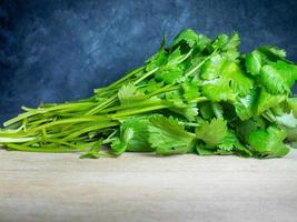 un bouquet de coriandre sur une planche à découper. produit utile. verts sur la table de la cuisine. ingrédient de déjeuner végétarien. beaucoup de tiges de coriandre photo