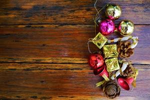 décorations sur le thème du nouvel an et des cadeaux de noël sur fond en bois, composées d'une boîte cadeau dorée. boules colorées brillantes pommes de pin séchées et petites cloches espace libre pour la conception photo