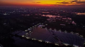 vue aérienne d'une ferme solaire produisant de l'énergie propre pendant la soirée au crépuscule. zone visible tout autour photo