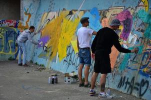 Kharkov. ukraine - 2 mai 2022 festival des arts de la rue. les jeunes gars dessinent des graffitis sur de vieux murs en béton au centre de la ville. le processus de peinture sur les murs avec des bombes aérosols photo