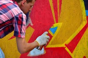 Kharkov. ukraine - 2 mai 2022 festival des arts de la rue. de jeunes gars dessinent des graffitis sur des murs en bois portables au centre de la ville. le processus de peinture sur les murs avec des bombes aérosols photo