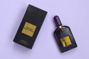 kharkov, ukraine - 3 mai 2022 la bouteille de parfum de parfum d'orchidée de velours tom ford se trouve sur un fond lilas clair. tom ford est un créateur de mode américain a lancé sa marque de luxe éponyme en 2006 photo