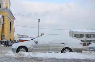kharkov, ukraine - 4 janvier 2022 une voiture garée sous une épaisse couche de neige. conséquences d'une chute de neige forte et inattendue en ukraine photo