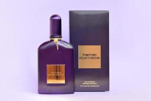 kharkov, ukraine - 3 mai 2022 la bouteille de parfum de parfum d'orchidée de velours tom ford se trouve sur un fond lilas clair. tom ford est un créateur de mode américain a lancé sa marque de luxe éponyme en 2006 photo